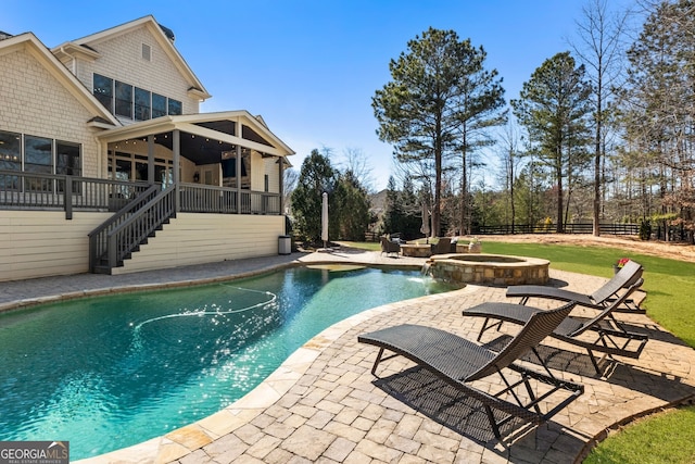 view of pool featuring a pool with connected hot tub, a patio, fence, stairway, and a sunroom