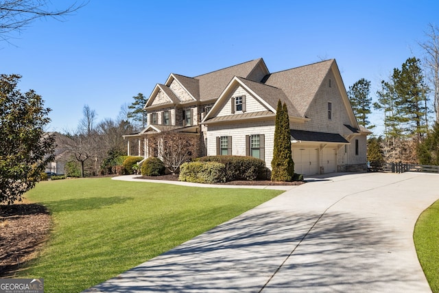 view of front of house featuring a front lawn, concrete driveway, and an attached garage