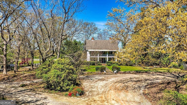 view of front of home featuring a front yard and dirt driveway