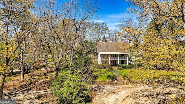 view of front of property with a chimney and a sunroom