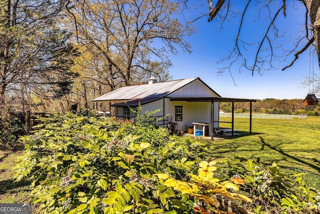 view of property exterior featuring metal roof and a yard