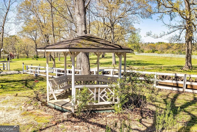 exterior space with a rural view, a gazebo, fence, and a lawn