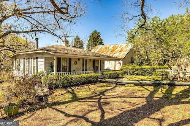 view of front of house featuring covered porch and a chimney