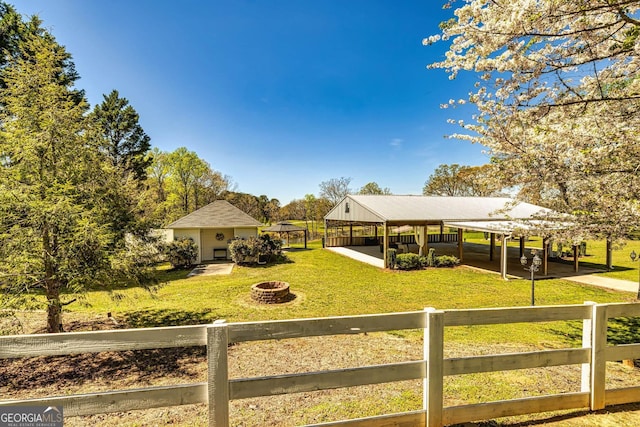 view of yard featuring an outbuilding and a fire pit