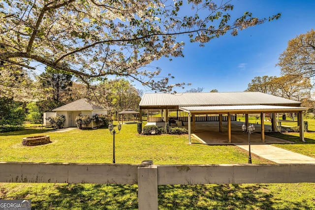 view of property's community featuring a lawn and an outdoor fire pit