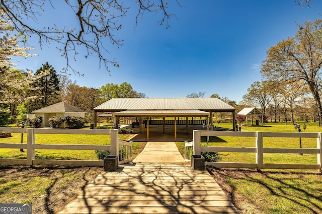 view of community with a gazebo, a lawn, and fence