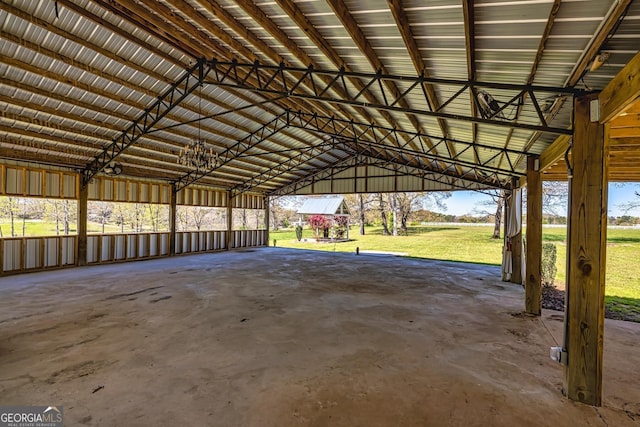 interior space featuring lofted ceiling, unfinished concrete floors, and metal wall