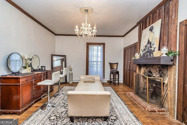 sitting room featuring a fireplace, crown molding, baseboards, and wood finished floors