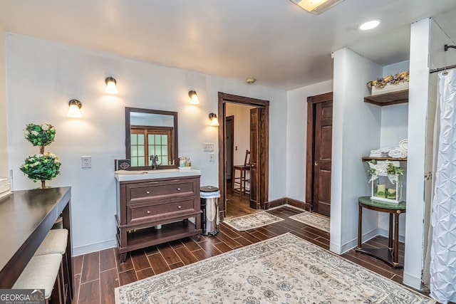 bathroom featuring baseboards, vanity, and wood tiled floor