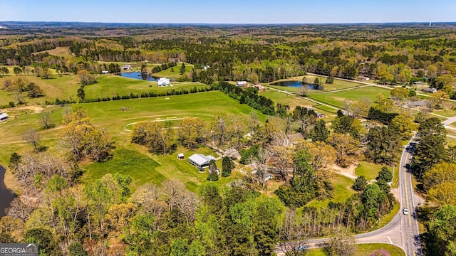 drone / aerial view with a forest view and a water view