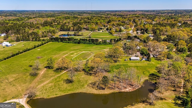 bird's eye view with a water view and a wooded view