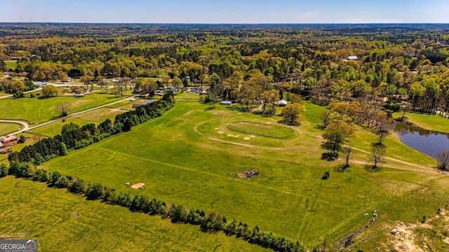 drone / aerial view with a wooded view and a water view