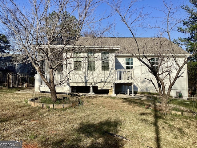 rear view of house with a shingled roof