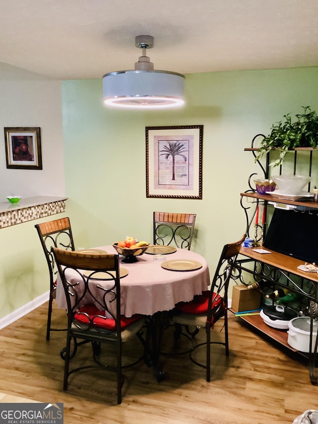 dining space featuring baseboards and wood finished floors