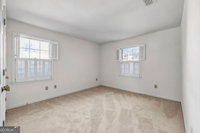 carpeted spare room with visible vents and baseboards