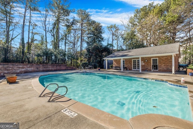 view of swimming pool featuring french doors, a fenced in pool, and a patio area