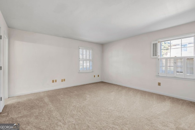 carpeted empty room featuring baseboards