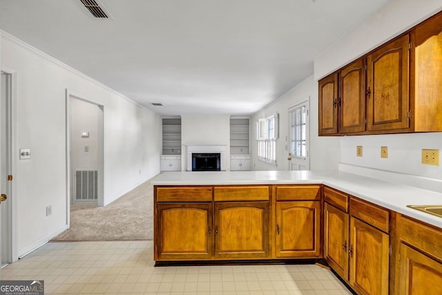 kitchen featuring open floor plan, a peninsula, light countertops, and visible vents