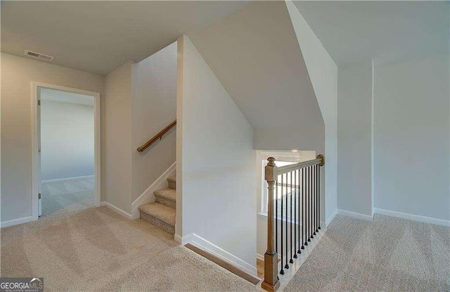 staircase featuring baseboards, visible vents, and carpet floors