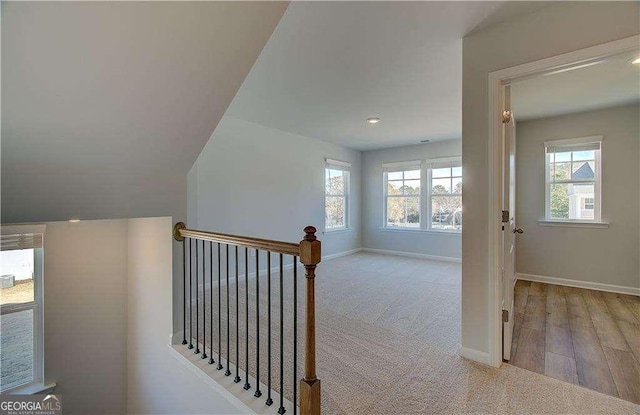 interior space with an upstairs landing, carpet, and baseboards