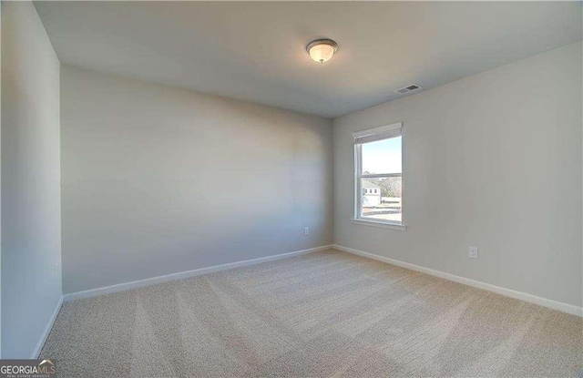 empty room with light carpet, visible vents, and baseboards