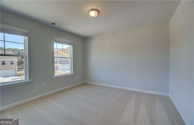 unfurnished room featuring visible vents, baseboards, and carpet floors