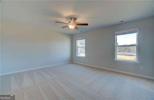 empty room with visible vents, baseboards, and light colored carpet