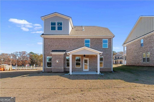 view of front of home featuring a front lawn, a patio area, and brick siding