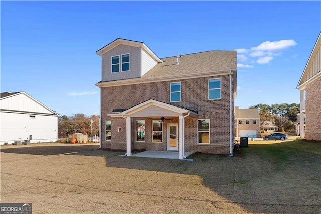 view of front of home with brick siding, a front lawn, a ceiling fan, and a patio