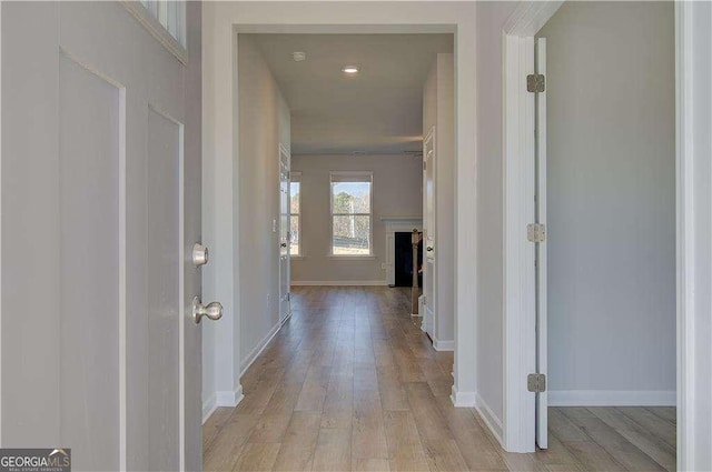 hall with baseboards and wood finished floors