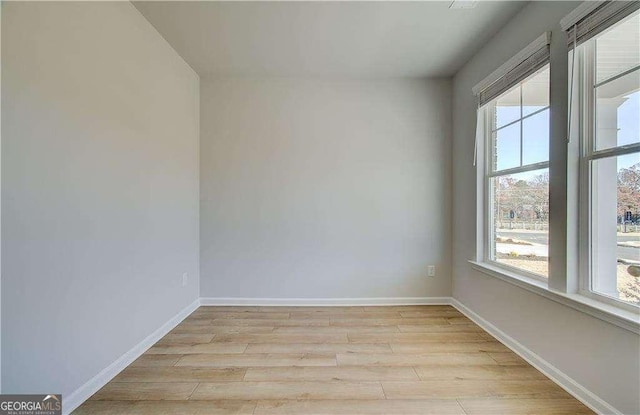 empty room with baseboards and light wood finished floors