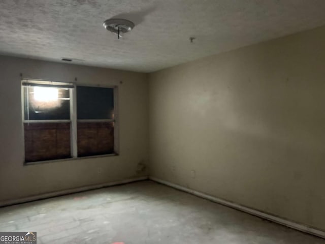 empty room featuring concrete floors and a textured ceiling