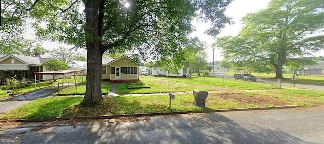 view of home's community with a yard and fence