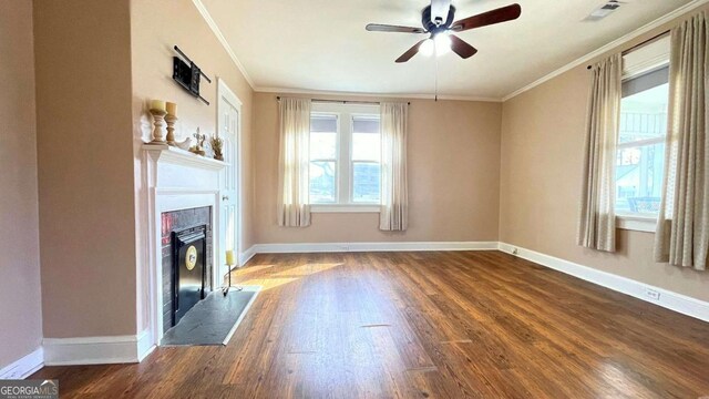 unfurnished living room featuring ornamental molding, a fireplace, dark wood-style floors, ceiling fan, and baseboards