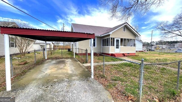 rear view of house featuring central AC, metal roof, and an outdoor structure