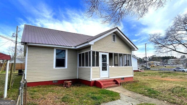 view of front of property featuring driveway, crawl space, and metal roof