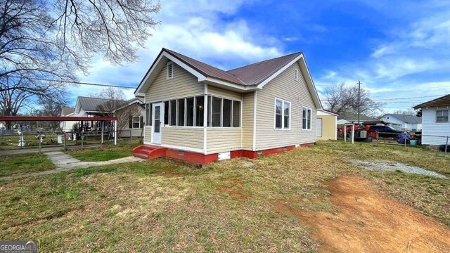 view of front facade with crawl space, entry steps, metal roof, and a sunroom