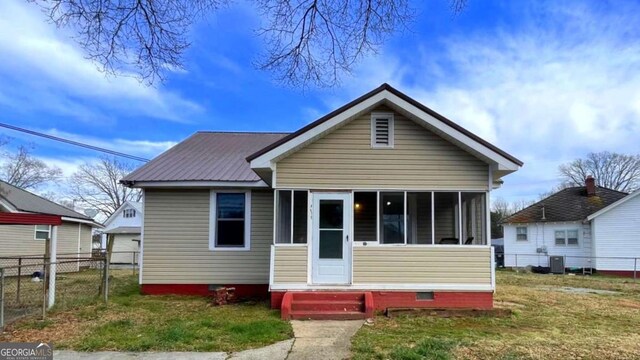 view of front of house featuring entry steps, crawl space, a sunroom, metal roof, and central AC