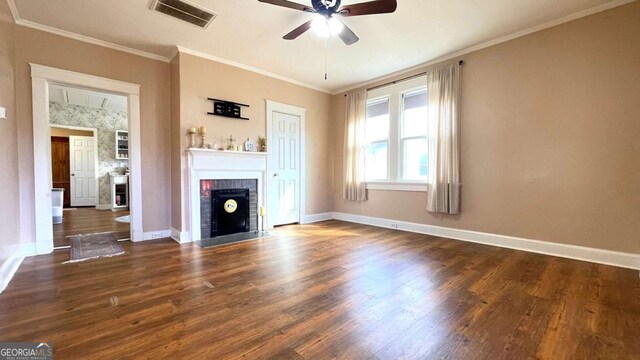 unfurnished living room featuring a ceiling fan, wood finished floors, a fireplace, baseboards, and ornamental molding
