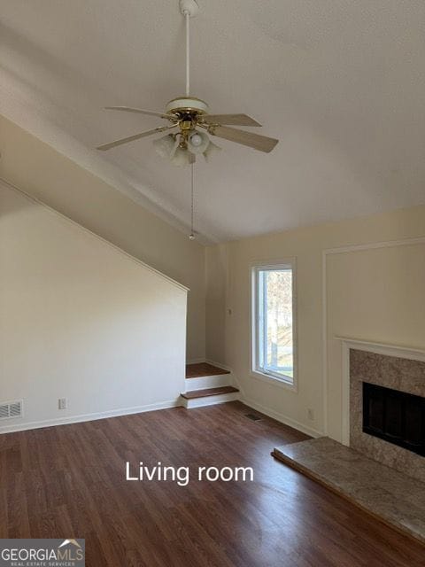 unfurnished living room featuring a ceiling fan, wood finished floors, visible vents, a premium fireplace, and lofted ceiling