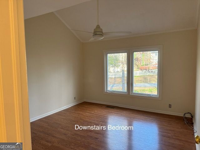 unfurnished room with ceiling fan, baseboards, and wood finished floors