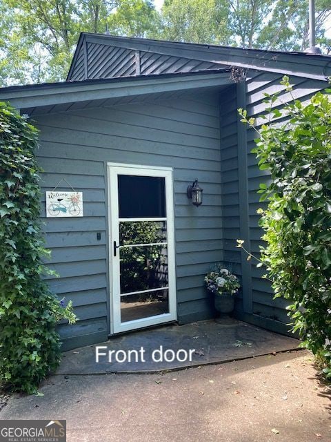 entrance to property featuring a standing seam roof and metal roof