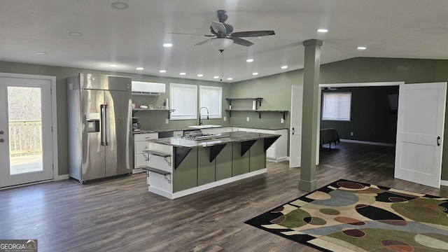 kitchen with a wall mounted air conditioner, stainless steel refrigerator with ice dispenser, open shelves, a sink, and a kitchen island