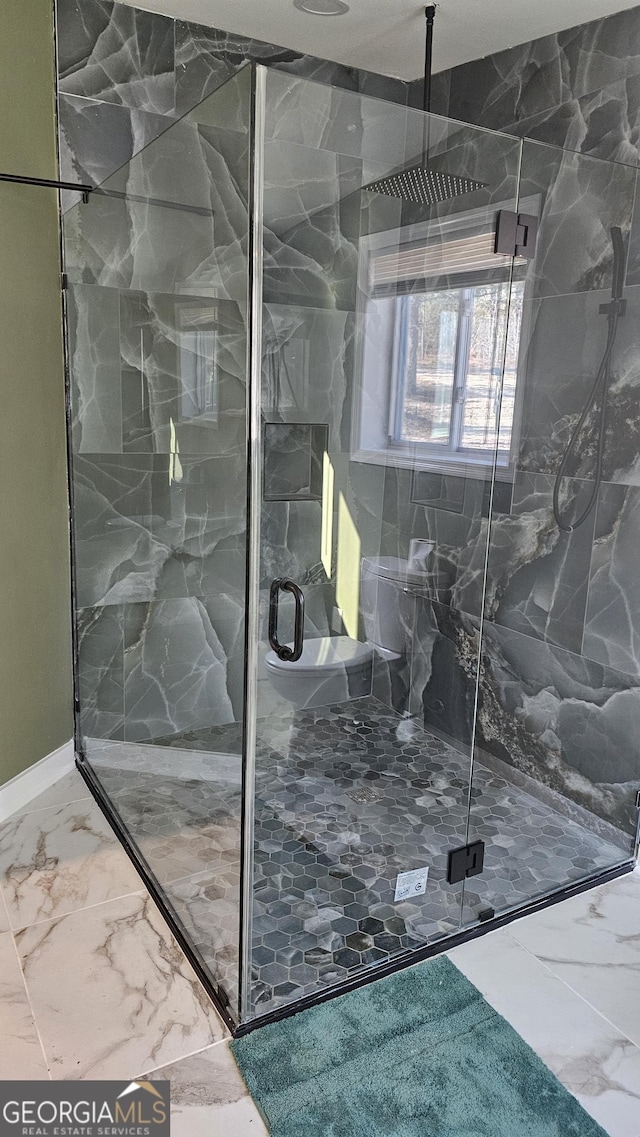 bathroom featuring marble finish floor and a marble finish shower