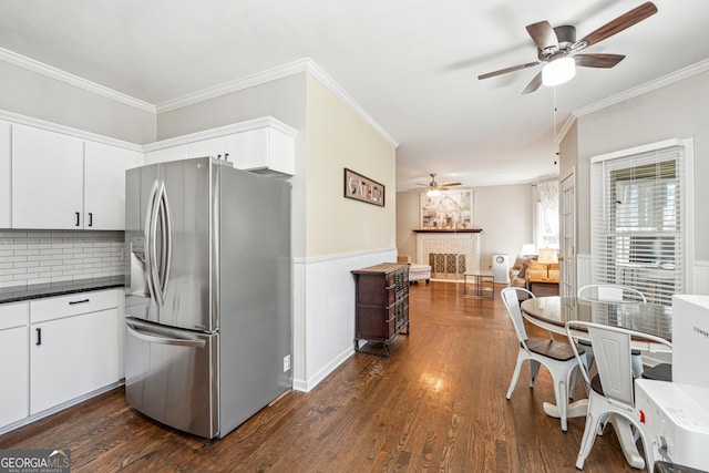 kitchen with dark wood-style floors, a brick fireplace, crown molding, and stainless steel fridge with ice dispenser