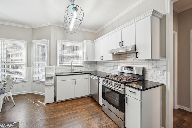 kitchen featuring under cabinet range hood, stainless steel appliances, dark countertops, and a sink