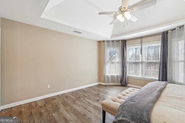 bedroom with visible vents, baseboards, lofted ceiling, wood finished floors, and a ceiling fan