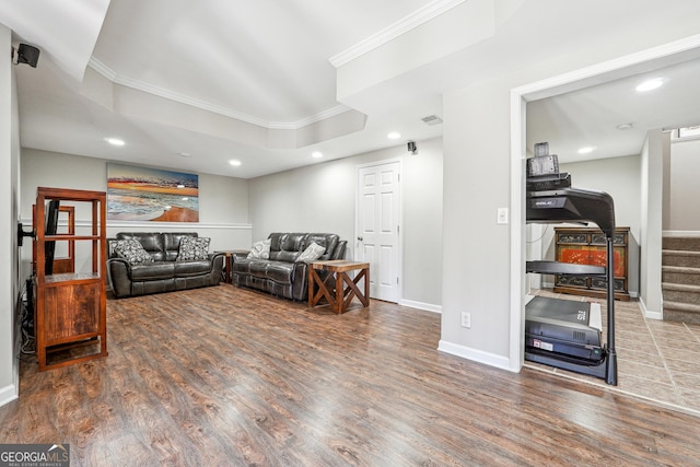 living room with ornamental molding, wood finished floors, recessed lighting, a raised ceiling, and stairs