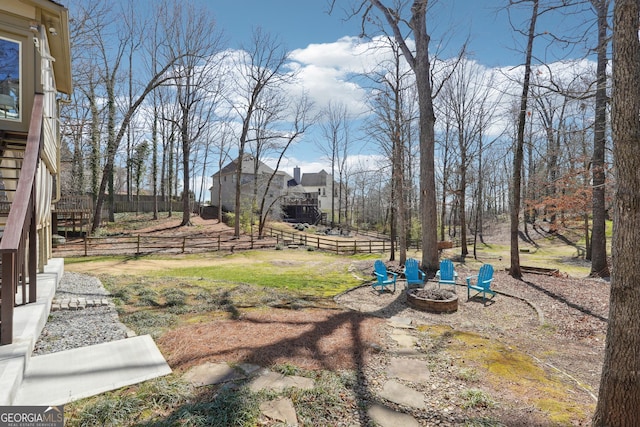 view of yard with a fire pit and fence