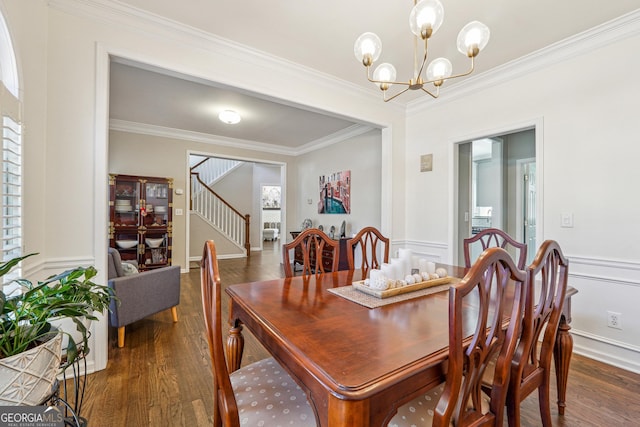 dining room featuring dark wood finished floors, an inviting chandelier, stairs, and ornamental molding